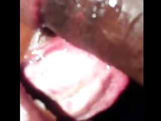 Schwarze Schönheit bläst und schluckt den langen Schwanz